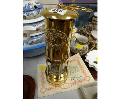 A brass miners lamp together with a certificate of origin made by E Thomas & Williams, Ltd