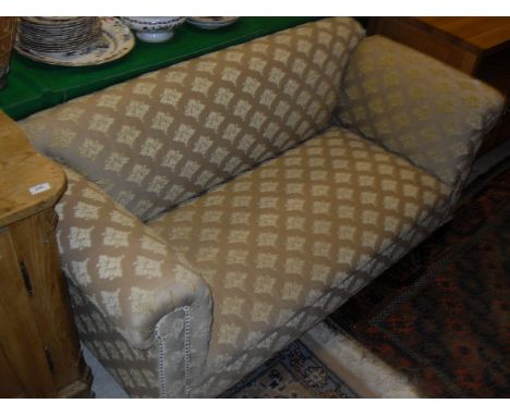 A circa 1900 sofa in a pale gold brocade upholstery on stained oak legs with single drop arm