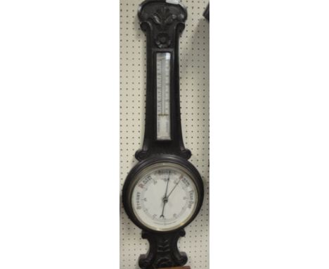 A Victorian carved oak cased aneroid barometer thermometer