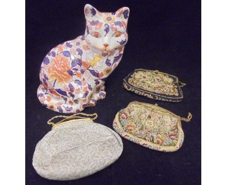 Three early to mid 20th Century evening bags with gilt metal mounts (two tapestry, one silk work), together with an Imari cat