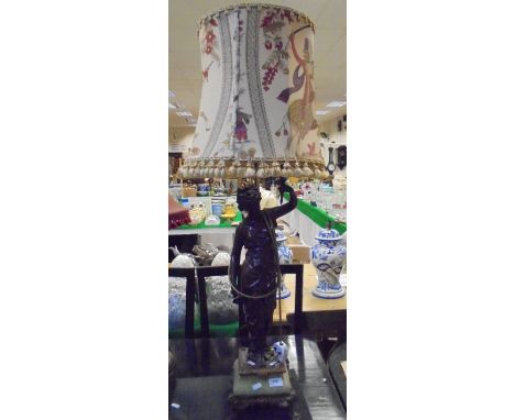 A chocolate patinated spelter figural table lamp with green onyx base on lion's paw feet