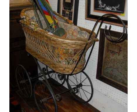 A Victorian wrought iron folding cot on castors, together with a vintage wrought iron and cane work dolls' pram, three variou