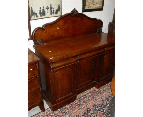 A Victorian mahogany sideboard, the raised back with moulded decoration over three cushion drawers and a recessed cupboard do