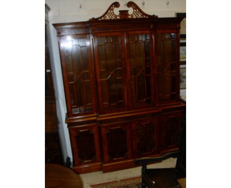 A modern walnut and cross banded breakfront dresser in the George III taste with broken arch pediment above a blind fretwork 