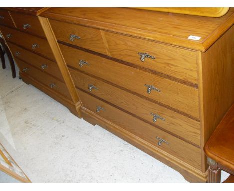 Two oak effect bedroom chests of two short over three long drawers to bracket feet