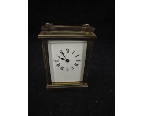 A 20th Century lacquered brass cased carriage clock, the enamel dial with Roman numerals
