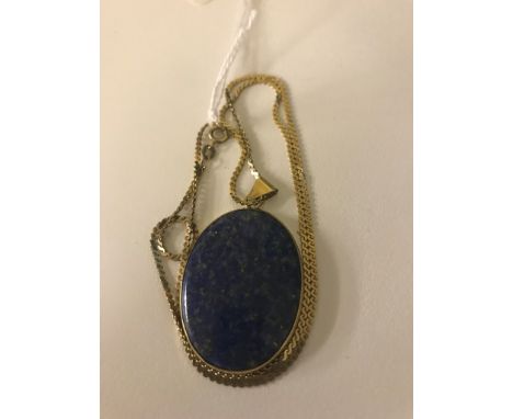 A lapis lazuli oval gold-mounted pendant on a gold chain