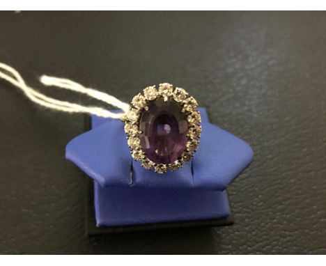 A modern repro dress ring comprising one central amethyst (est 4.50ct) surrounded with 16 brilliant-cut diamonds - 1.28ct tot