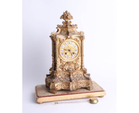 A heavy French gilt mantle clock with bell strike and pendulum with enamel cartouche dial, ornate case on gilt platform base,