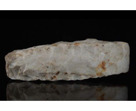 Ca. 4th - 2nd Millennium BC.A thick-butted axe head made of light cream flint. With an elongated trapezoid outline and convex