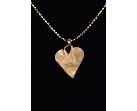 Ca. 100-300 AD.A gold pendant formed of a thin sheet of gold, modelled in the shape of a leaf. The pendant is attached to a s