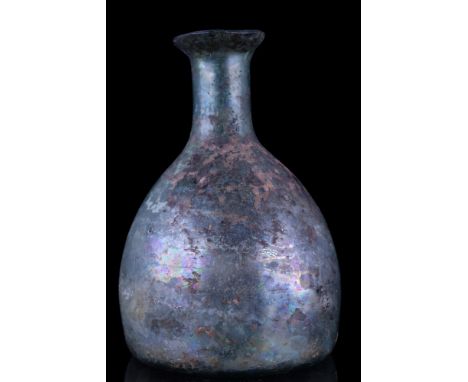 Ca. 100-300 AD.A free-blown glass flask of a conical-shaped body, concave base with a pontil mark, tubular neck with everted 