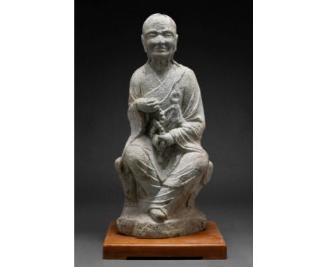 Ca. 618-907 AD.The figure is shown seated on a tree trunk wrapped in his priestly robes and holding clasps of a rosary (praye