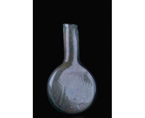 Ca. 100-300 AD.A finely blown ampulla flask of aqua-coloured glass. The vessel features a flat, spherical body, a long cylind