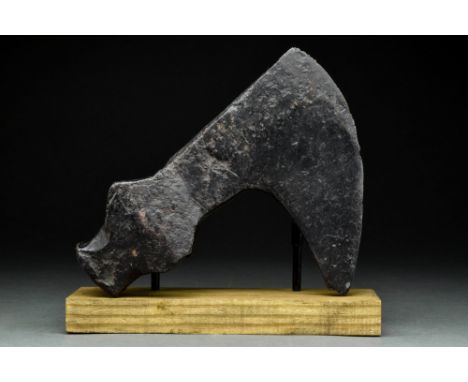 Ca. 900-1100 AD.An iron axe head comprising a curved, fan-shaped blade, tapering cheek, and rounded, reinforced socket with a