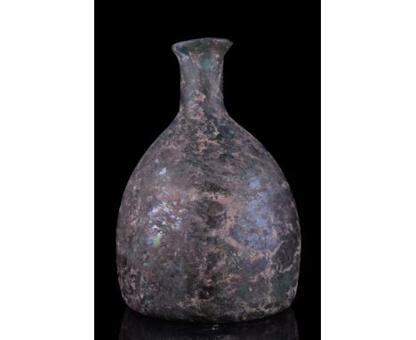 Ca. 100-200 AD.A free-blown glass flask of a conical-shaped body, concave base with a pontil mark, tubular neck with everted 