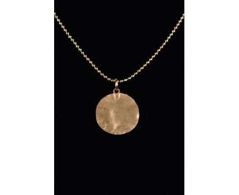 Ca. 200-300 AD.A finely rendered gold disc-shaped pendant, hammered from thin gold with a suspension loop. This piece is full