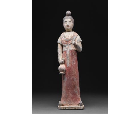 Ca. 618-907 AD.A mould-formed pottery tomb attendant figure in the form of a woman who is wearing a long robe with a red-pain