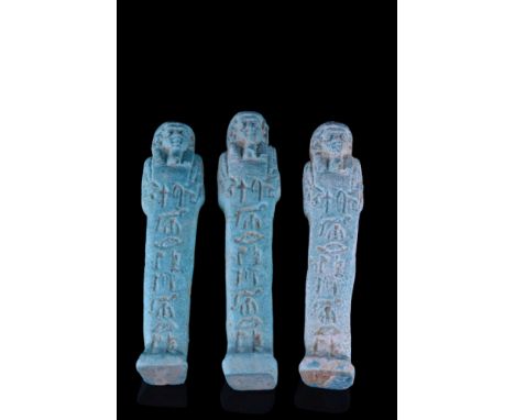 Late Period, 30th Dynasty, Ca. 332 BC.A group of three ushabti figures, each moulded in a light-blue, glazed faience, wearing