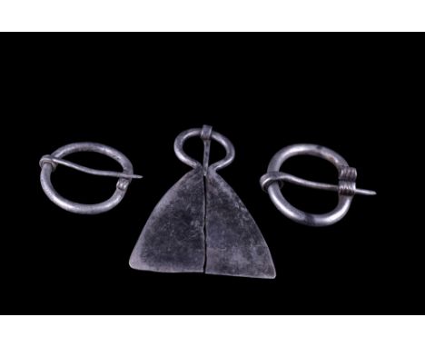 Ca. 900-1100 AD.A group of three silver penannular brooches including two 'omega' type fibulas. Each with a round-section sha