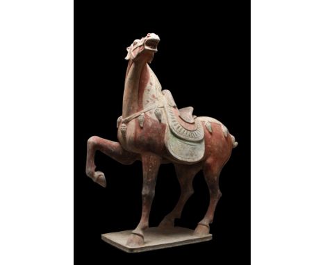 Ca. 618-907 AD.A beautiful pottery figure of a prancing horse. The spirited horse is shown with the right foreleg raised, man