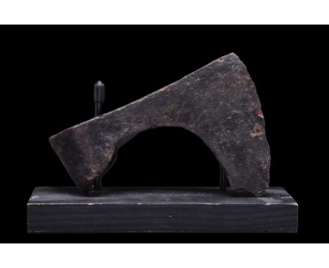 Ca. 900-1100 AD.A forged-iron axe head of a hefty form with a perforated socketing shaft, a dense neck, and a vertically orie