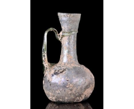 Ca. 200-300 AD.A beautiful jug featuring an ovoidal body, flaring, funnel-shaped neck and a high-arching handle connecting th