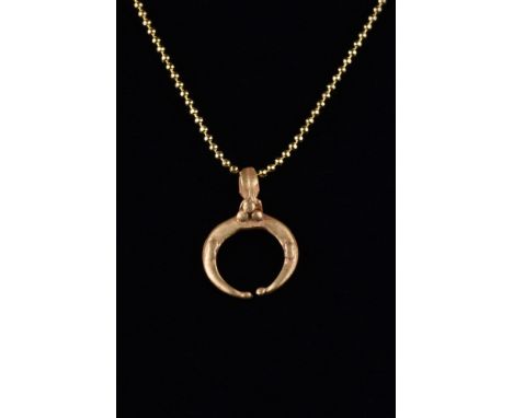 Ca. 100-300 AD.A gold lunar amulet comprises a crescent moon with a suspension loop and applied spheres. In Roman mythology, 