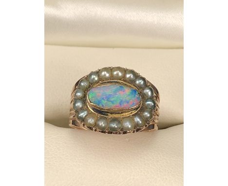 Georgian Mourning Ring set with an oval Black Opal measuring approx: 5.5mm x 10.3 across. Surrounded by 17 small grey Seed Pe