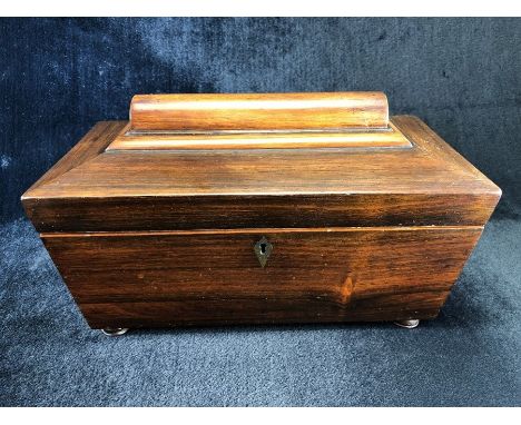 A 19TH CENTURY RECTANGULAR SARCOPHAGUS SHAPED TEA CADDY, with two compartments and a rose coloured glass bowl on turned bun f