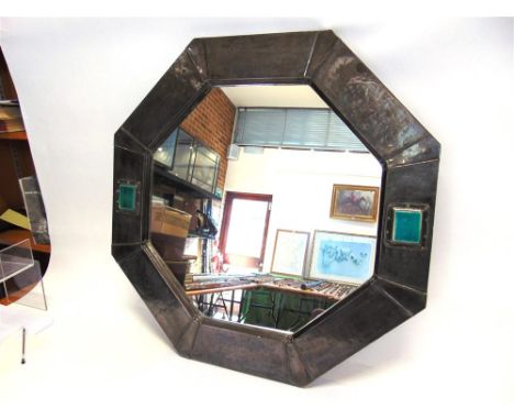 AN ARTS & CRAFTS OCTAGONAL WALL MIRROR,  the pewter coloured hand beaten frame applied with rectangular enamel plaques, 69cm 