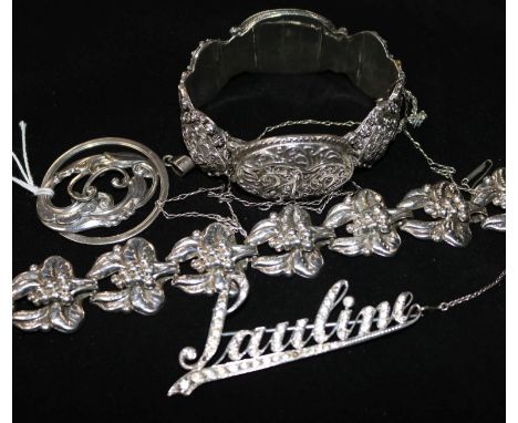 A silver bracelet, pendant and brooch and a white metal hinged bangle.