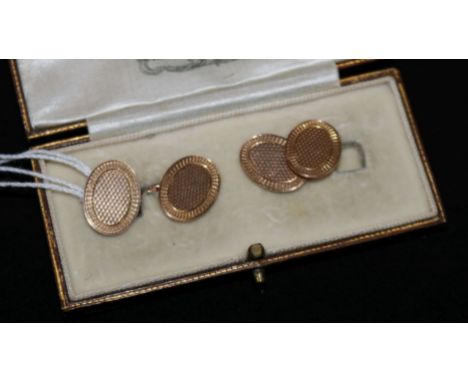 A cased pair of engine turned 9ct gold cufflinks.