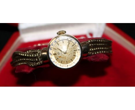 A lady's 9ct gold Omega manual wind wrist watch on an associated quadruple strand bracelet, with Omega box.