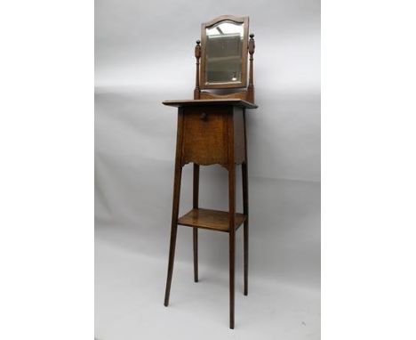 AN EDWARDIAN OAK MAID'S DRESSING STAND, fitted bevel plate swivel mirror to back, over a base with drop front storage compart