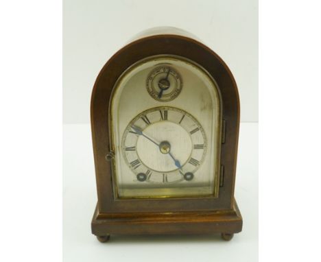 A MINIATURE MAHOGANY CASED GEORGIAN DESIGN MANTEL CLOCK of arched form, having silvered dial with Roman numerals, 8-day chimi