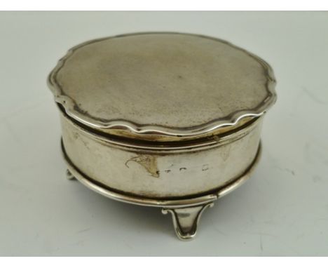 A SILVER TRINKET BOX, having fancy edge hinged cover revealing blue silk lined interior, hallmarks worn, raised on four feet,