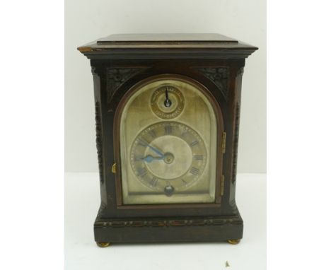 AN EDWARDIAN OAK CASED MANTEL CLOCK, dial with chapter ring bearing Roman numerals, raised on brass bun feet, fitted with an 