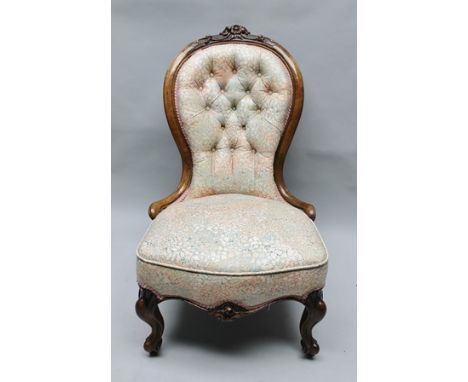 A VICTORIAN CARVED MAHOGANY SHOW-WOOD FRAMED BUTTON BACK SALON CHAIR upholstered in cream ground and pattern fabric, raised o