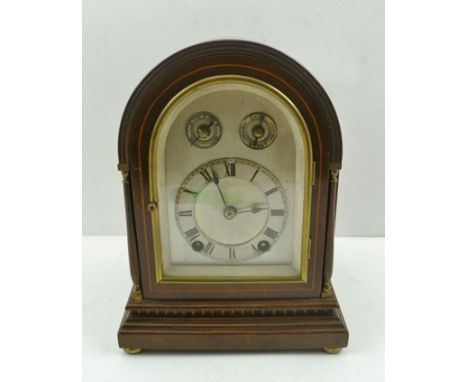 AN EDWARDIAN MAHOGANY CASED CHIMING MANTEL CLOCK, having arch top case, raised on brass bun feet, silvered dial with Roman nu