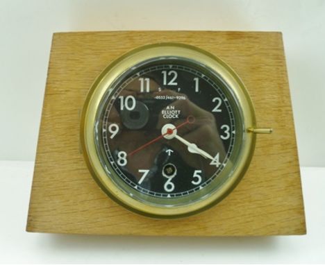 AN ELLIOTT CLOCK, having brass bezel, black face with War Department arrow, and no. 0552/461-9296, the brass cased movement s