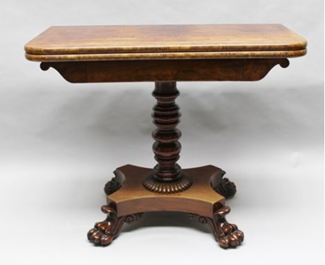 A 19TH CENTURY MAHOGANY FOLD-OVER CARD TABLE, having crossbanded top, green baize lined interior, on ring turned stem, on pla