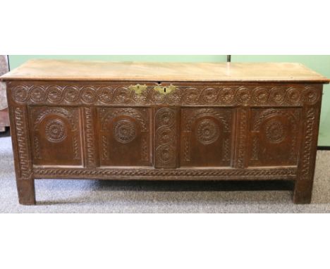 18th century carved oak coffer the moulded hinged top above four panels, all carved with stylised flowerheads roundels with a