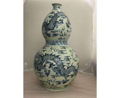 A large blue and white double gourd Oriental vase with dragons and flaming pearl decoration