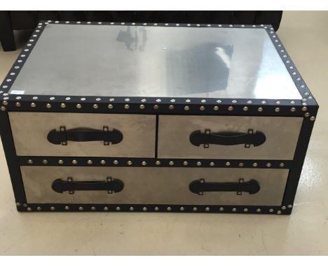 A chrome trunk/coffee table with drawers to side