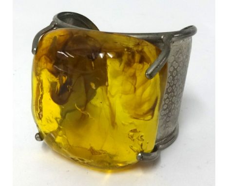 A Philippe Ferrandis Paris pewter bangle set with a large amber style stone.