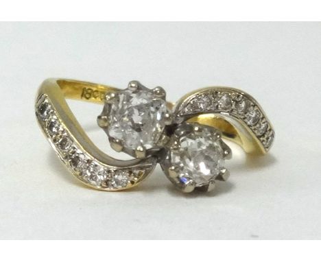 An 18ct gold crossover ring set with two old cut diamonds, approx .50 carats total, further diamonds set to the shoulders, fi