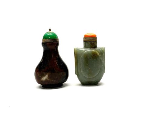 A Chinese carved jade snuff bottle with gilt metal and coral stopper, H. 7cm, together with a further polished stone snuff bo
