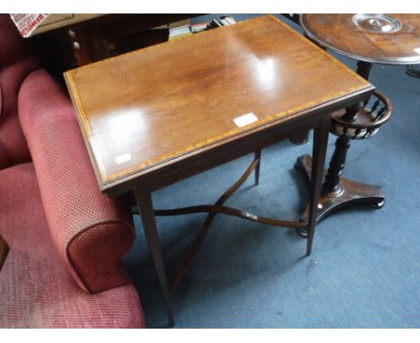 AN EDWARDIAN MAHOGANY AND CROSSBANDED FOLD-OVER TOP CARD TABLE on tapering legs, 21" wide