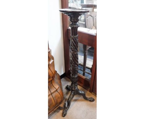 A CARVED MAHOGANY TORCHERE on tripod base, 47" high
